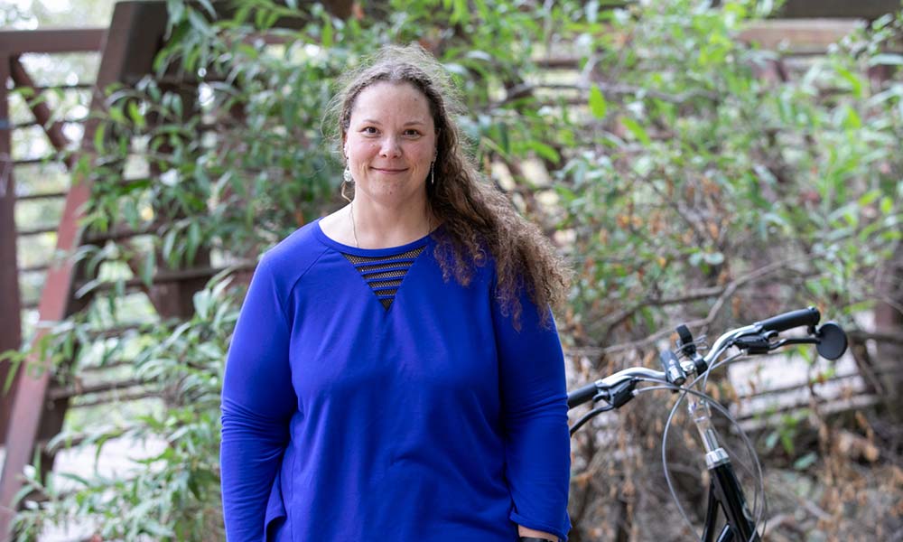 Christina standing next to a bike in a garden